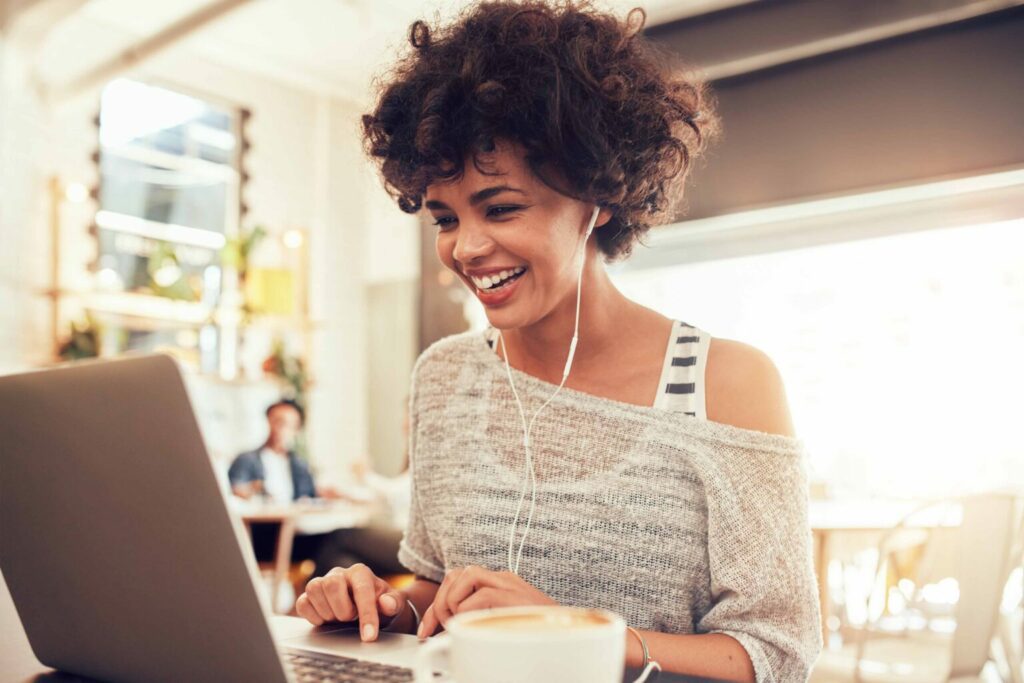 Женщина улыбается во время работы за ноутбуком